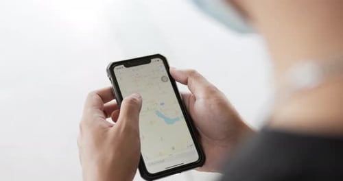 Adult Navigating Map Application on Smartphone