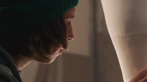 Young Man Creating Sculpture in Workshop