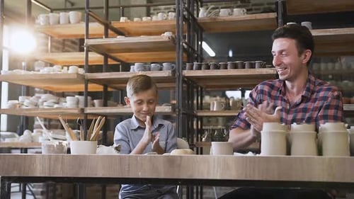 Child Learns Pottery Making With Adult Guidance
