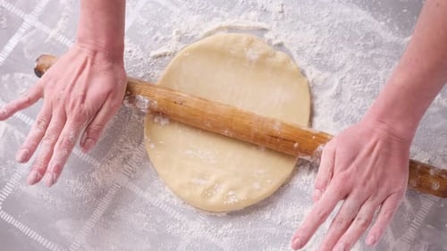 Dough Being Rolled with Rolling Pin