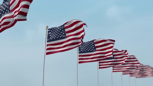 Patriotic Waving American Flags Against Blue Sky