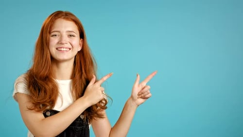 Smiling Woman Pointing to the Side on Blue