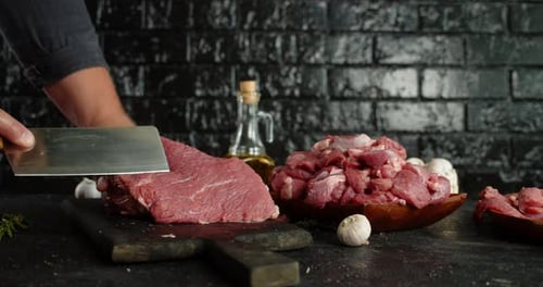 Cutting Raw Meat in Kitchen with Cleaver