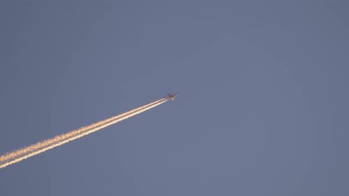 Aeroplane Flying in Clear Blue Sky Leaving Contrails