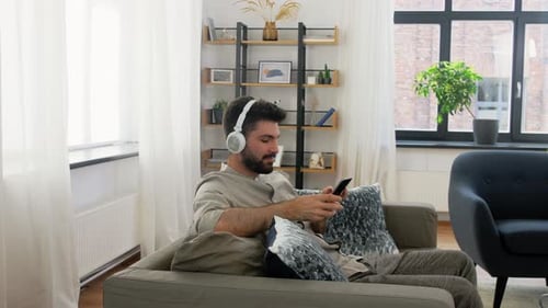 Man Listening to Music on Headphones at Home