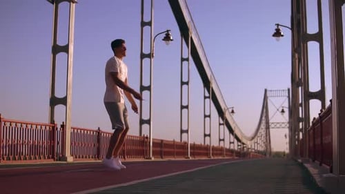 Side View of a Man Jumping on the Bridge
