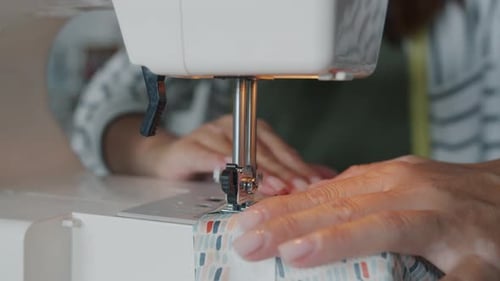 Woman Using Sewing Machine to Sew Fabric