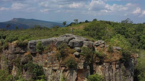 Drone view Young hiking woman standing on rocky peak