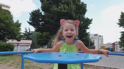 Nettes lächelndes Mädchen hat Spaß auf einem Karussell