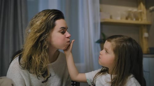 Woman and Child Interact Affectionately at Table