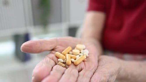 Senior Hands Holding Pills for Health Treatment