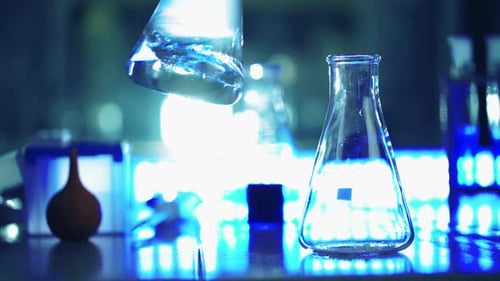 Gloved Hand Swirls Liquid in Lab Flask