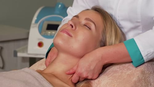 Attractive Woman Getting Facial Spa Treatment at Beauty Salon