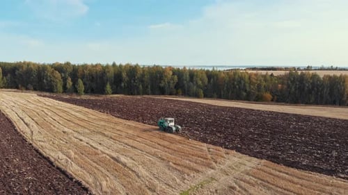 An Autumn Landscape of Fields and Sky - Tractors Plows the Field