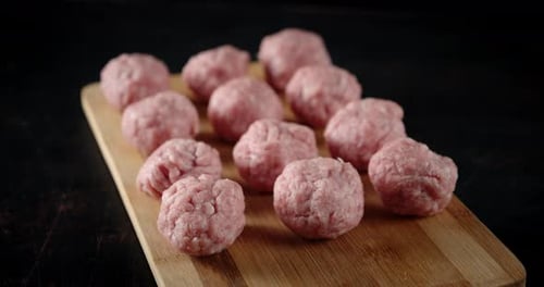 Raw Meatballs on Wooden Cutting Board Close Up