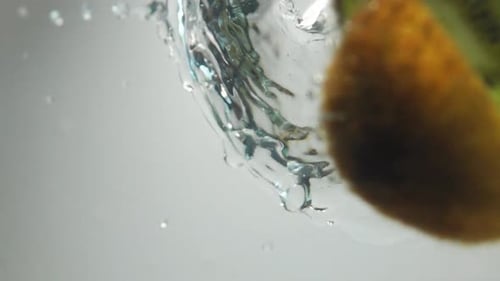 Kiwi Slices Splashing into Water