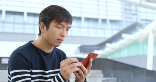 Man Using Phone in Modern Urban Environment