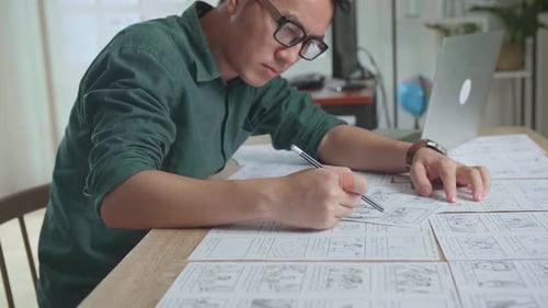 Asian Man Drawing Storyboard Animation Comic Cartoon, Design Creative Scene Layout At Studio