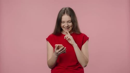 Young Woman Uses Phone on Pink Background