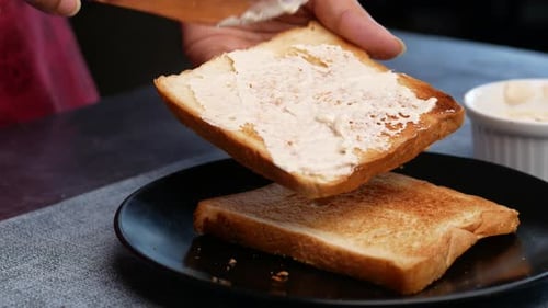 Spreading Cream Cheese on Toast for Breakfast
