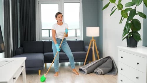 Woman Dancing While Sweeping the Floor at Home