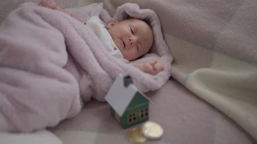 Sleeping Baby with Toy House and Coins
