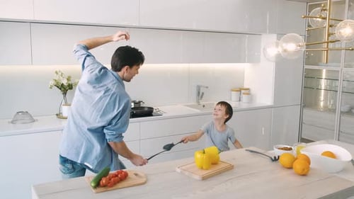 Father and Son Play Fighting with Kitchen Utensils