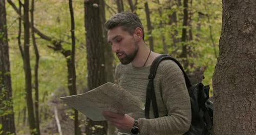 Confident Male Caucasian Tourist Putting on His Backpack, Closing Map and Leaving. Side View of