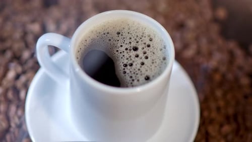 Close Up of Cup of Coffee with Beans