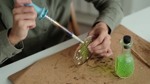 Artist Soldering Glass Art With Dried Flowers