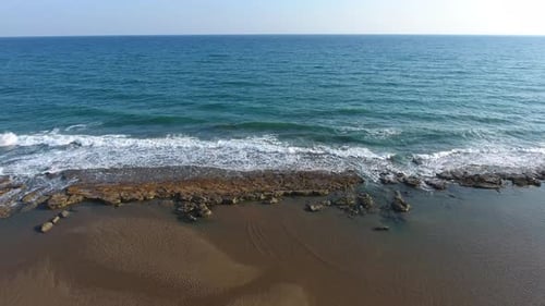 Flaches Felsenriff zwischen Meer und Strand