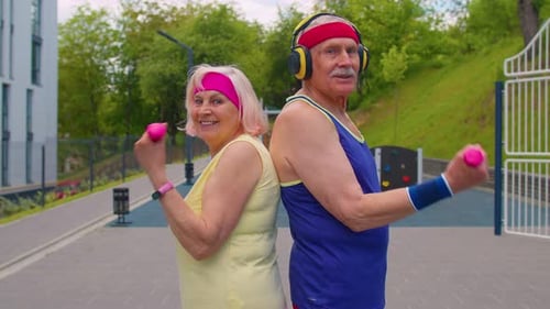 Active Senior Couple Lifting Weights Outdoors