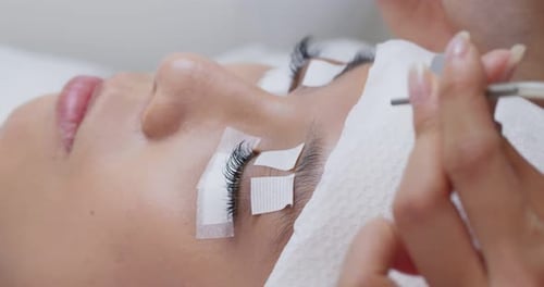 Mulher com extensão de cílios no salão de beleza