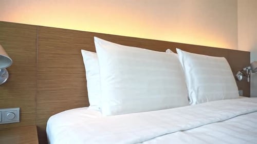 Clean bed with white pillows and linens