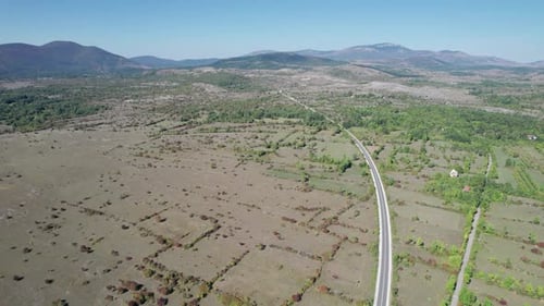 Aerial View Empty Asphalt Road on the Plateau Between Green Fields Highland Way