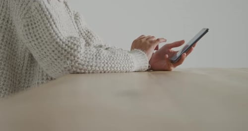 Woman Using Cell Phone at Table