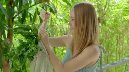 Mujer joven pone un apio en una bolsa reutilizable, concepto de reducir la contaminación por plástico