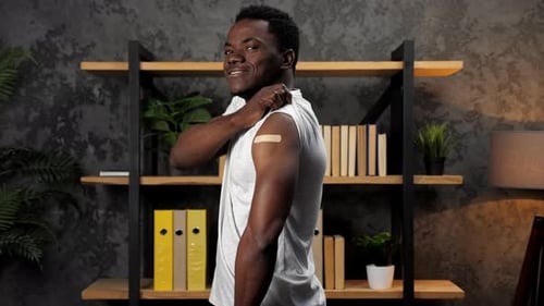 Young Adult Showing Arm Bandage Giving Thumbs Up