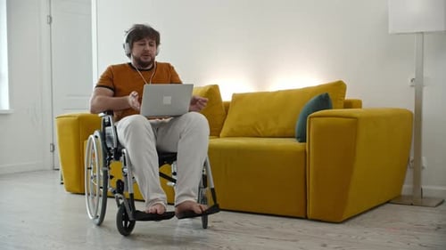 Man in Wheelchair Uses Laptop for Video Call