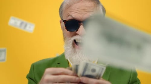 Hombre de edad feliz contando dinero en el estudio