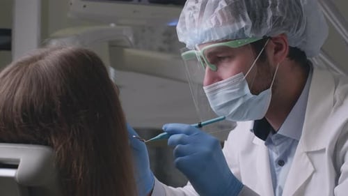 Professional Dentist Man Making Check Up for Female Patient in Modern Dental Office Close Up Slow