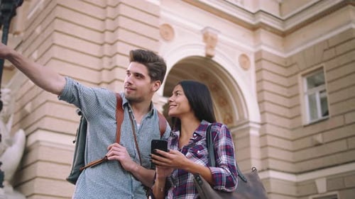 Ein paar junge Touristen gemischter Rassen nutzen Smartphone-GPS auf der Straße und suchen langsam nach Orten