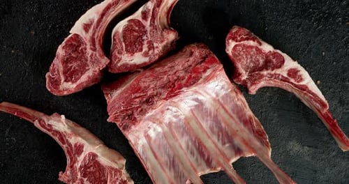 Pieces of Raw Rack of Lamb Slowly Rotate on the Table.