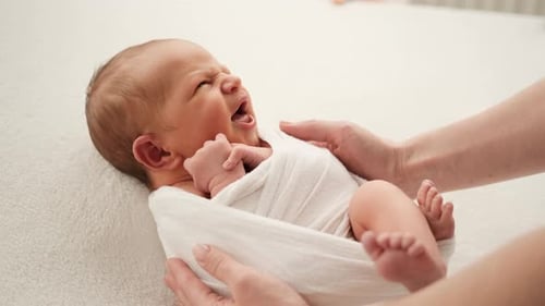 Swaddled Infant Cries in Parents' Arms