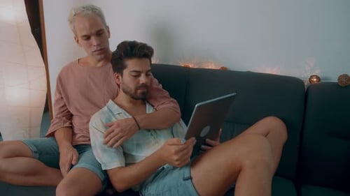 Loving Couple Relaxing Together Using Tablet at Home