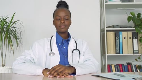 Smiling Woman Doctor Sitting at Desk