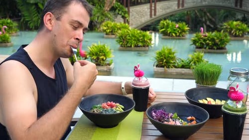 Man Eating Colorful Meal in Tropical Setting