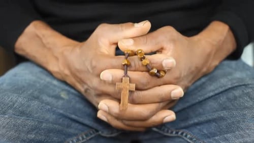 Man Holding Wooden Prayer Beads in Hands