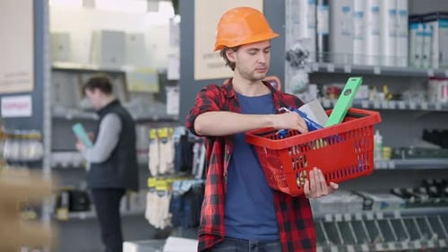 Young Man Shopping in Hardware Store with Basket