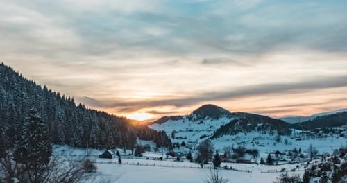 Beautiful Cloudy Sunrise With Golden Sun Rays Shining Behind Snowy Mountain Forest - Time Lapse